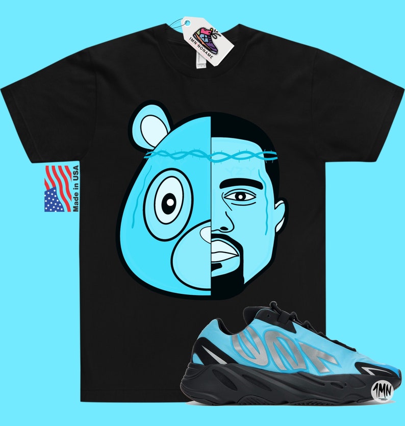 May include: Black t-shirt with a blue and black illustration of a bear and a man's face.  The t-shirt is paired with blue and black sneakers with the word "Yeezy" on the side.