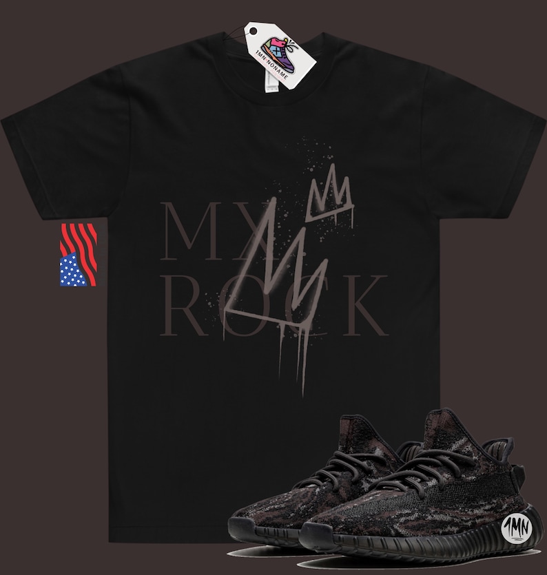 May include: Black t-shirt with the text "MY ROCK" and a crown graphic. A pair of black and grey camouflage sneakers with a black sole.