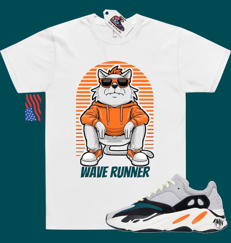 May include: White t-shirt with a cartoon cat wearing sunglasses and an orange hoodie. The cat is sitting on a striped background with the text "Wave Runner". A pair of grey, black, and orange sneakers are shown below the t-shirt.