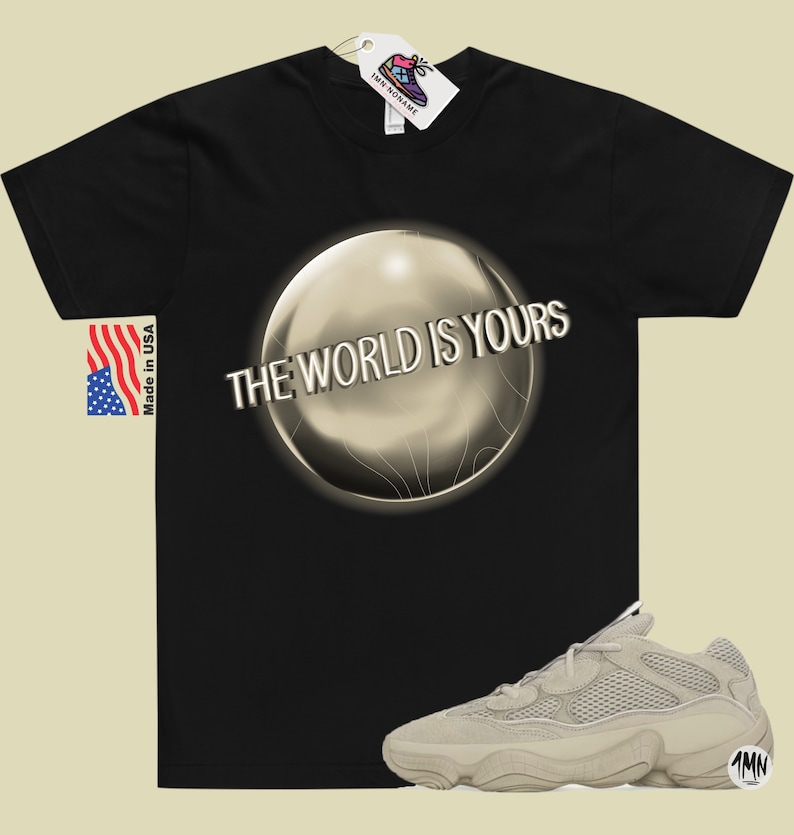 May include: Black t-shirt with a silver orb graphic and the text "THE WORLD IS YOURS". A pair of beige sneakers with a mesh upper and a thick sole.