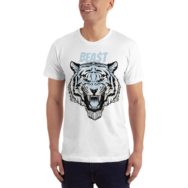 K&ouml;nnte beinhalten: Wei&szlig;es T-Shirt mit einem Aufdruck eines wei&szlig;en Tigerkopfes mit schwarzem Umriss und dem Wort "BEAST" in blauer Schrift &uuml;ber dem Tiger.