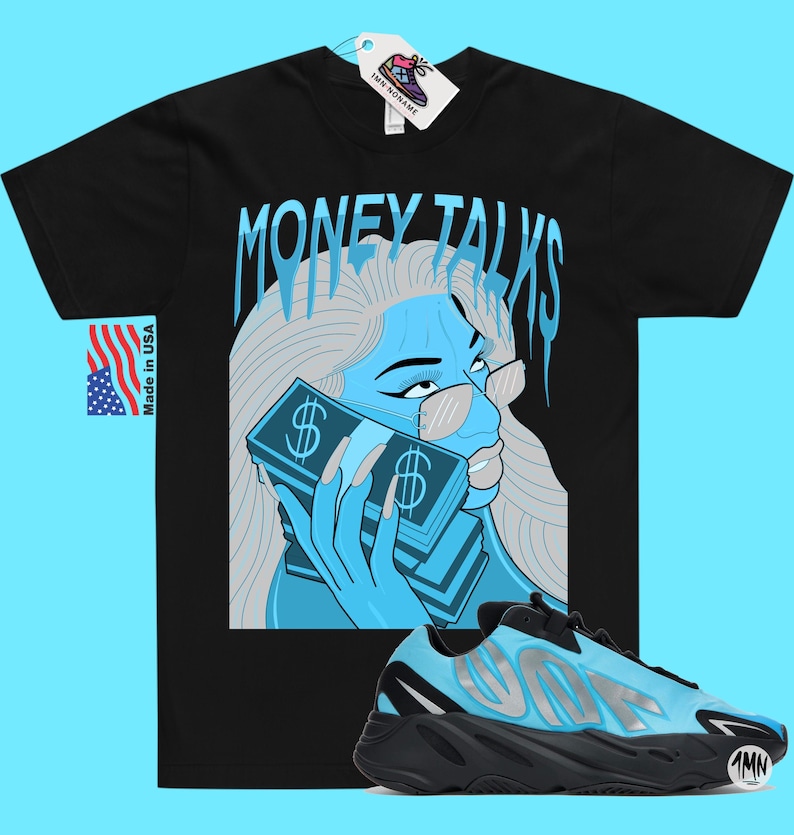 May include: Black t-shirt with a blue and white illustration of a woman holding a stack of money. The text "MONEY TALKS" is written in a dripping font above the woman. A pair of blue and black sneakers are shown below the illustration.