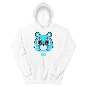 May include: White hoodie with a blue cartoon bear face wearing a chain with a pendant. The bear has stitches on its face and a cloud on its head.
