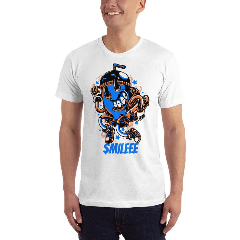 May include: White t-shirt featuring a blue and orange cartoon character of a smiling cup with a straw. The character is wearing trainers and has a blue and orange hat. The text "$MILEEE" is printed below the character.