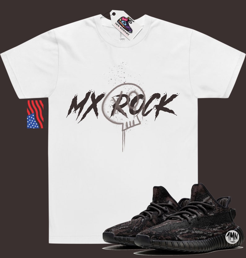 May include: White t-shirt with a black and white graphic of a skull and the text "MX ROCK".  A pair of black and brown sneakers with a camouflage pattern.