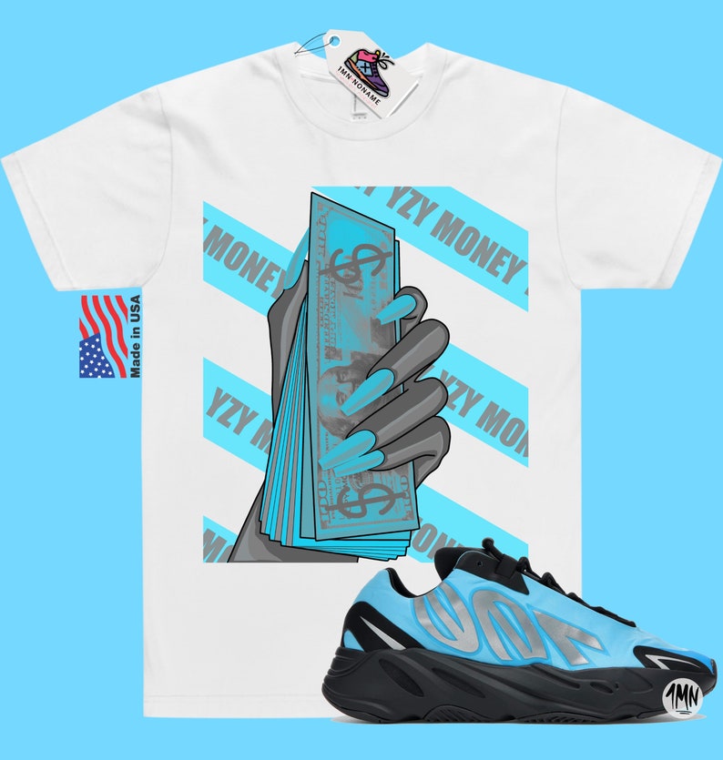 May include: White t-shirt with a graphic of a hand holding a stack of blue bills with the text "YZY MONEY" repeated across the shirt. A pair of black and blue sneakers with the text "YZY" on the side are shown below the shirt.