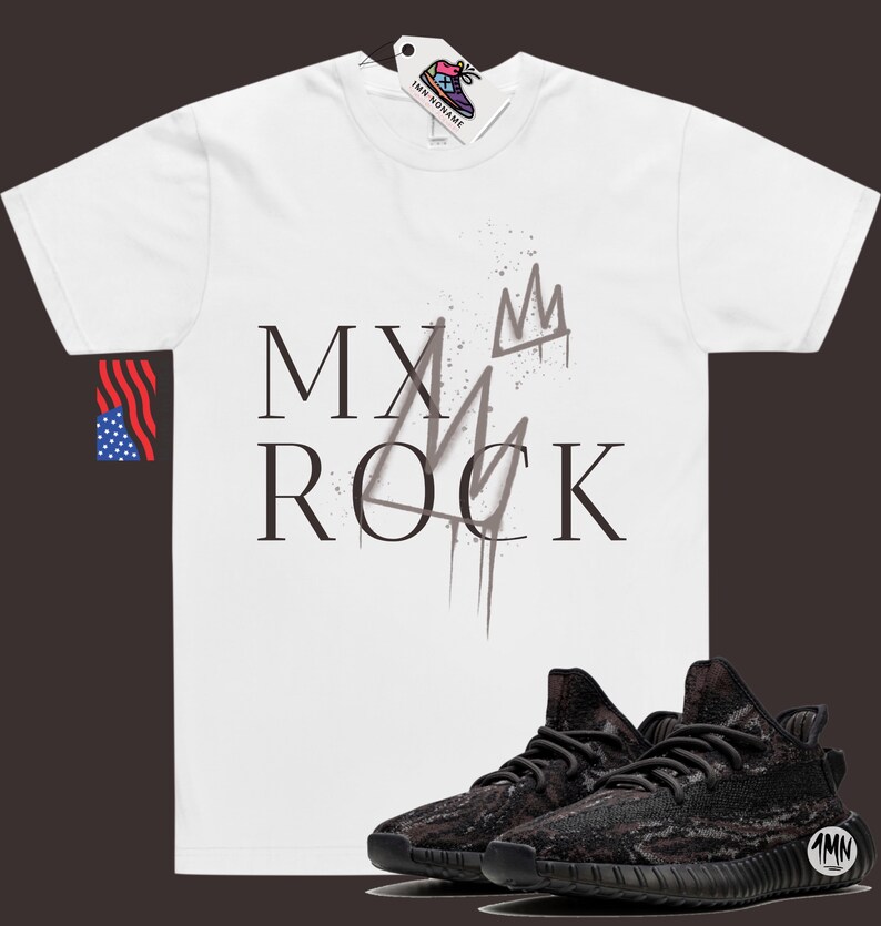 May include: White t-shirt with the text "MY ROCK" and a crown graphic. The shirt is paired with black and brown camouflage sneakers.