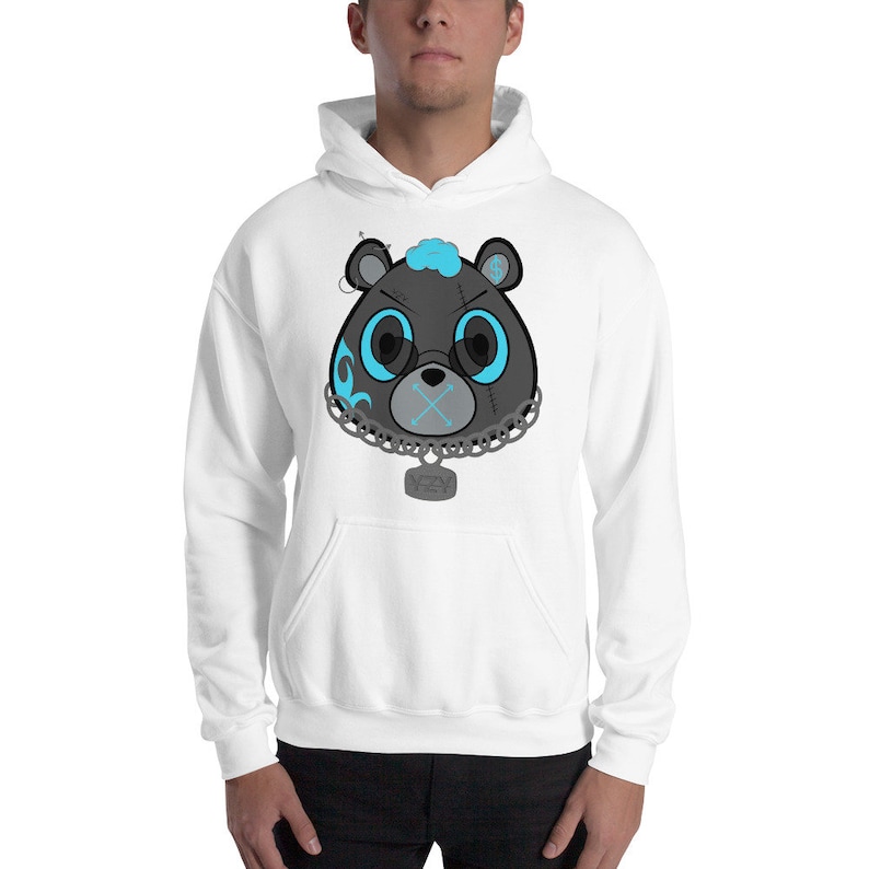 May include: White hooded sweatshirt with a black and blue cartoon bear head graphic. The bear has a chain around its neck with a tag that says "YEA".