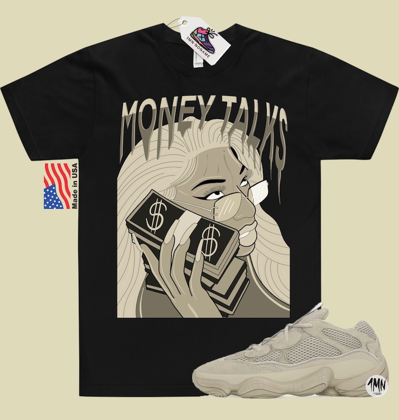 May include: Black t-shirt with a graphic of a woman with blonde hair wearing glasses and holding a stack of money. The text "MONEY TALKS" is above the woman's head. A pair of beige sneakers are in the bottom right corner of the image.