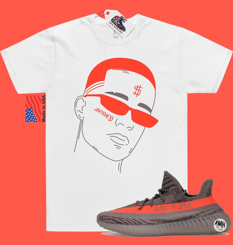 May include: White t-shirt with a red and gray illustration of a person wearing sunglasses and a bandana with the word "Money" and a dollar sign. The t-shirt is paired with gray and red sneakers.