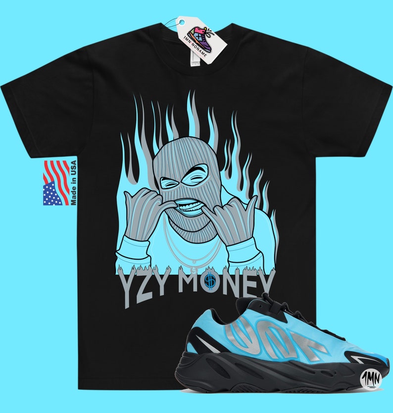 Puede incluir: Camiseta negra con una ilustraci&oacute;n azul y gris de una persona con pasamonta&ntilde;as y el texto "YZY MONEY". Un par de zapatillas azules y negras con el texto "YZY" en el lateral.