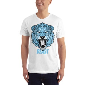 May include: White t-shirt with a blue lion graphic and the word "BEAST" printed below it.
