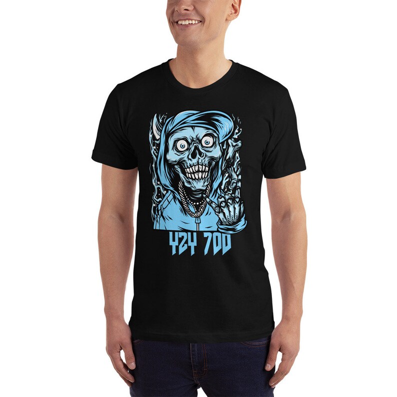 May include: Black t-shirt with a graphic of a blue skull wearing a blue hoodie and giving the middle finger. The text "424 700" is printed below the skull.