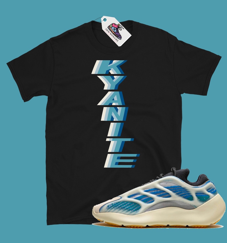Może przedstawiać: Czarny T-shirt z nadrukiem słowa "KYANITE" w pionie, niebieskimi i białymi literami. Koszulka jest połączona z białymi i niebieskimi butami sportowymi z ż&oacute;łtą podeszwą.