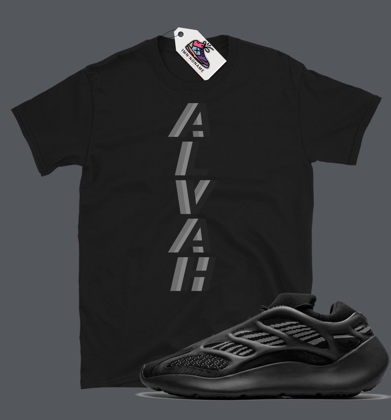 Puede incluir: Camiseta negra con la palabra "ALVAH" impresa verticalmente en gris y negro. Un par de zapatillas negras con una parte superior de malla y una suela blanca gruesa.