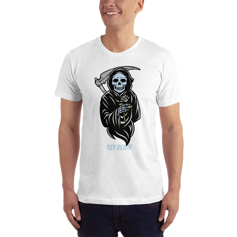 May include: A white t-shirt featuring a black and blue illustration of the Grim Reaper holding a rose. The text "YZY DEATH" is printed below the illustration.