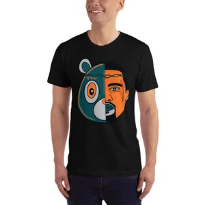 May include: Black t-shirt with a graphic of a cartoon bear with a human face. The bear is wearing a crown of thorns and the text "YZY" is on its forehead.