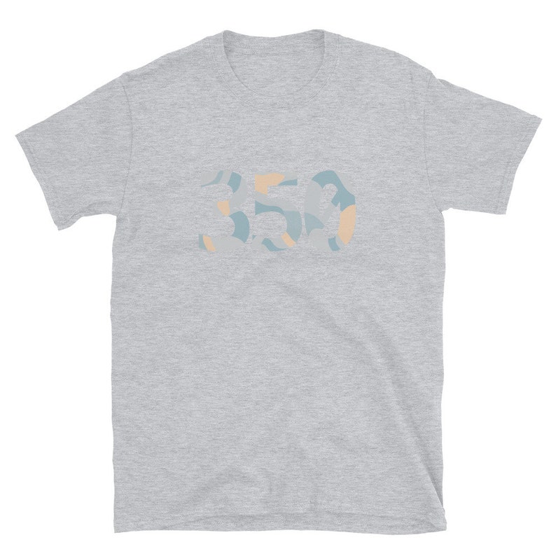 K&ouml;nnte beinhalten: Ein graues T-Shirt mit kurzen &Auml;rmeln und einem abstrakten Design in Blau und Orange, auf dem vorne "350" steht.