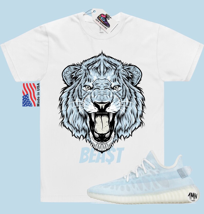 Peut inclure: T-shirt blanc avec un motif de lion bleu et le mot "BEAST" imprim&eacute; en dessous. Le t-shirt est associ&eacute; &agrave; des baskets bleu clair et blanches.