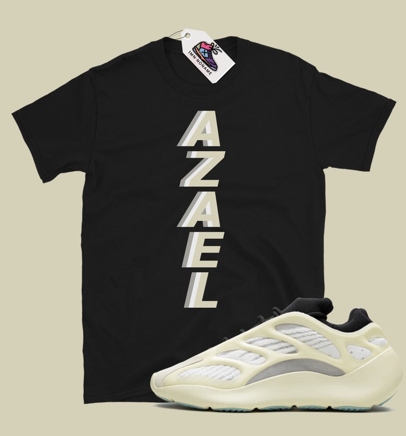 May include: Black t-shirt with the word "AZAEL" printed vertically in a light beige color. A pair of white and beige sneakers with a black tongue and laces.