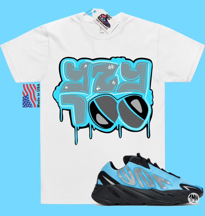 May include: White t-shirt with a blue and gray graphic that says "Yeezy Too" and a pair of blue and black sneakers with the word "Yeezy" on the side.