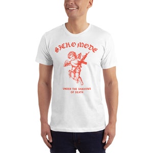 May include: White t-shirt with a red graphic of a cherub holding a rifle. The text "Sicko Mode" is above the cherub and "Under the Shadows of Death" is below the cherub.