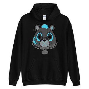May include: Black hoodie with a graphic of a blue and black cartoon bear with a chain and a tag that says "YZY".