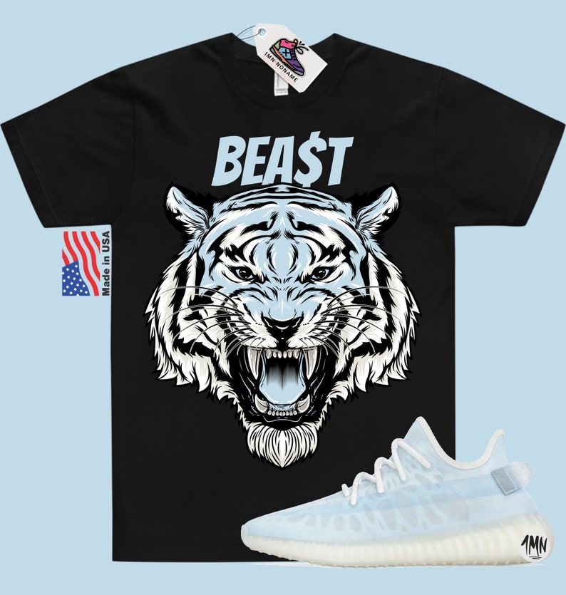 K&ouml;nnte beinhalten: Schwarzes T-Shirt mit einem wei&szlig;en Tiger-Motiv und dem Wort "BEAST" in wei&szlig;en Buchstaben. Das T-Shirt wird mit hellblauen Sneakern mit wei&szlig;er Sohle kombiniert.