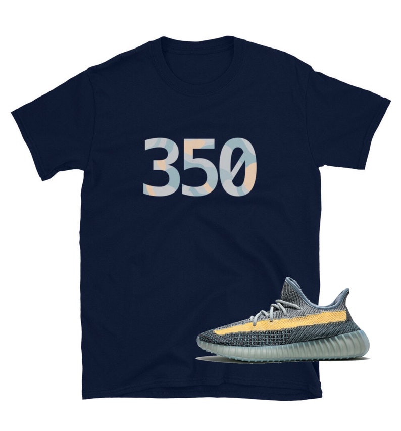 K&ouml;nnte beinhalten: Ein marineblaues T-Shirt mit der Nummer "350" auf der Vorderseite in einem hellblauen und gelben Tarnmuster. Unter dem Shirt ist ein Paar hellblaue und gelbe Sneaker zu sehen.