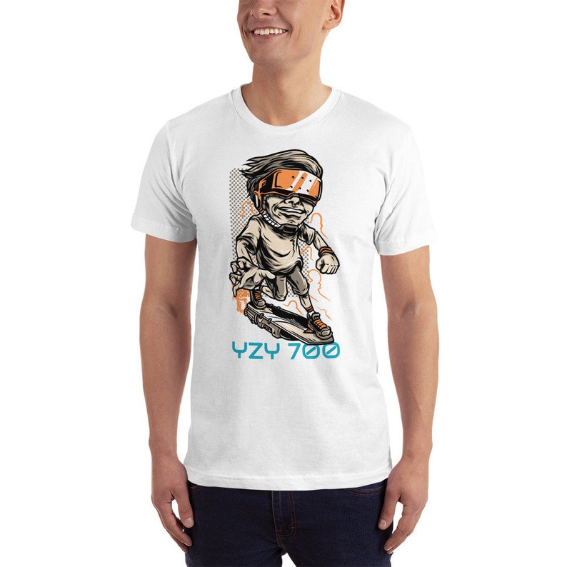 May include: White t-shirt with a cartoon illustration of a person wearing a futuristic helmet and riding a skateboard. The text "YZY 700" is printed below the illustration.