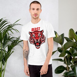 May include: White t-shirt with a red tiger graphic and the word "BEAST" in red letters.