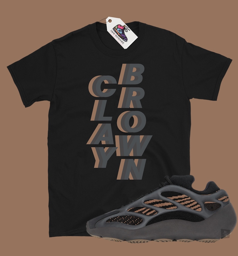 May include: Black t-shirt with the word "CBRAWYN" in layered gray and brown text. A gray and brown sneaker is positioned below the shirt. A white tag with a shoe graphic hangs from the shirt.