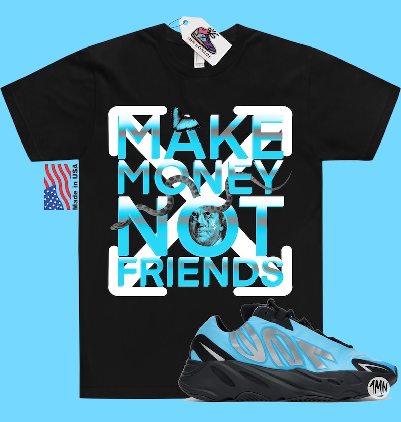 May include: Black t-shirt with a graphic print of the text "MAKE MONEY NOT FRIENDS" in white and blue with a snake and a dollar bill image. The t-shirt is paired with a black and blue sneaker.