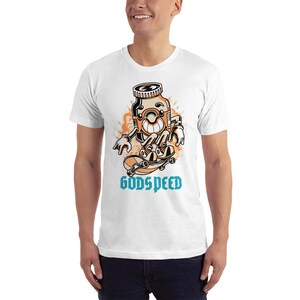 May include: White t-shirt with a cartoon illustration of a pill bottle skateboarding. The pill bottle has a smiling face and is wearing sneakers. The text "GODSPEED" is printed below the illustration.