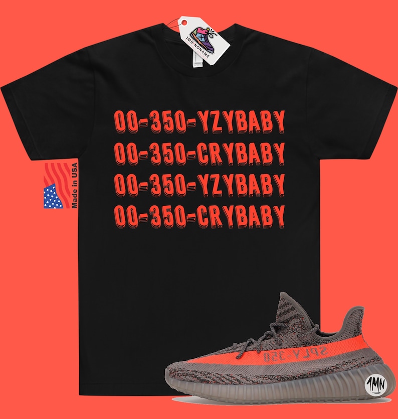 Peut inclure: T-shirt noir avec le texte "00-350-YZBABY" et "00-350-CRYBABY" r&eacute;p&eacute;t&eacute; en rouge. Une paire de baskets grises et orange avec le texte "350-YZY" sur le c&ocirc;t&eacute;.