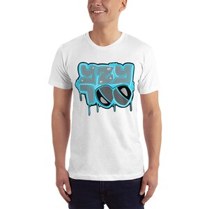 May include: White t-shirt with a blue and gray graphic design that says "YZY TOO" with sunglasses.