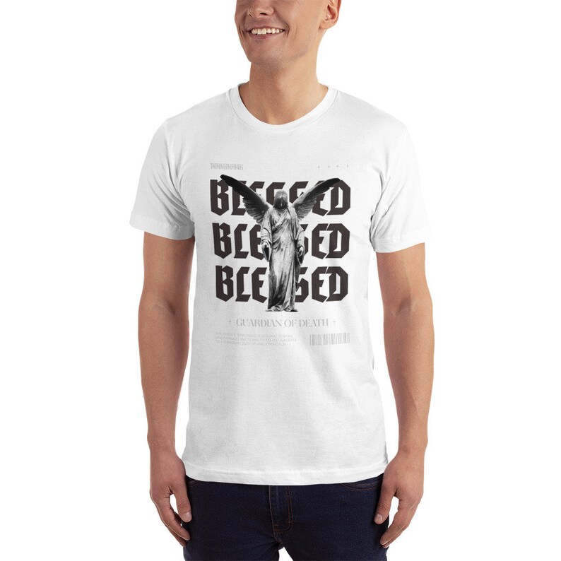 May include: White t-shirt with a black and white graphic print of an angel with wings and the text "Blessed" repeated four times. The text "Guardian of Death" is also printed on the shirt.