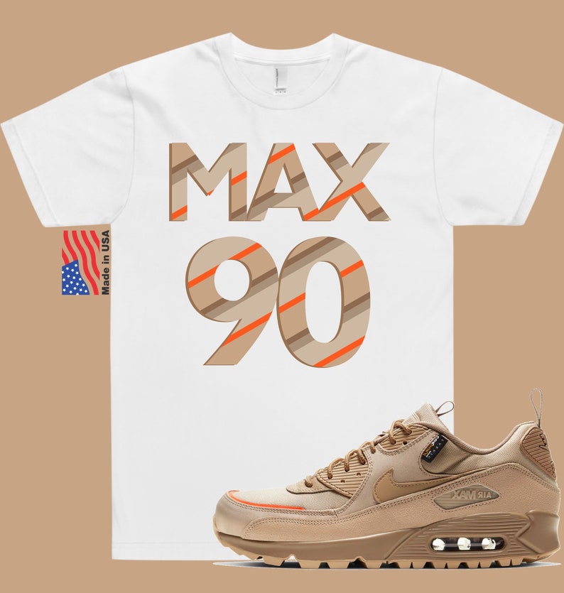 May include: A white t-shirt with the text "MAX 90" in brown and orange stripes. A pair of tan Nike Air Max 90 trainers with orange accents.