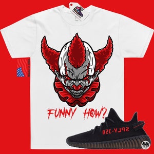 May include: White t-shirt with a red and white clown face graphic and the text "FUNNY HOW?" printed in red. A black and red sneaker with the text "SPLY-350" printed in red is also shown.