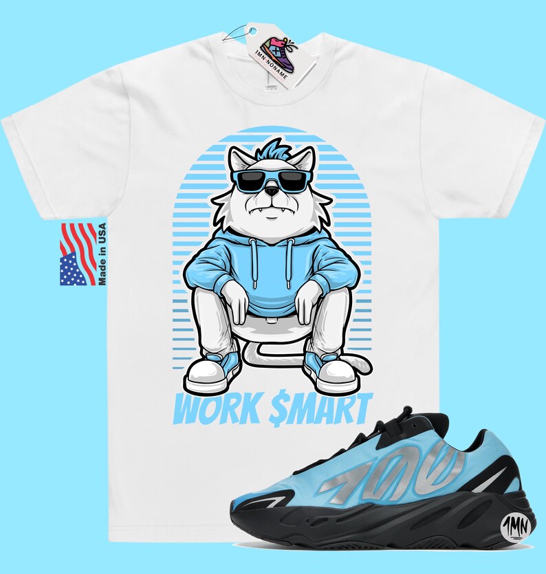 May include: White t-shirt featuring a cartoon illustration of a cat wearing sunglasses and a blue hoodie. The text "WORK $MART" is printed below the cat. A pair of blue and black trainers are shown below the t-shirt.