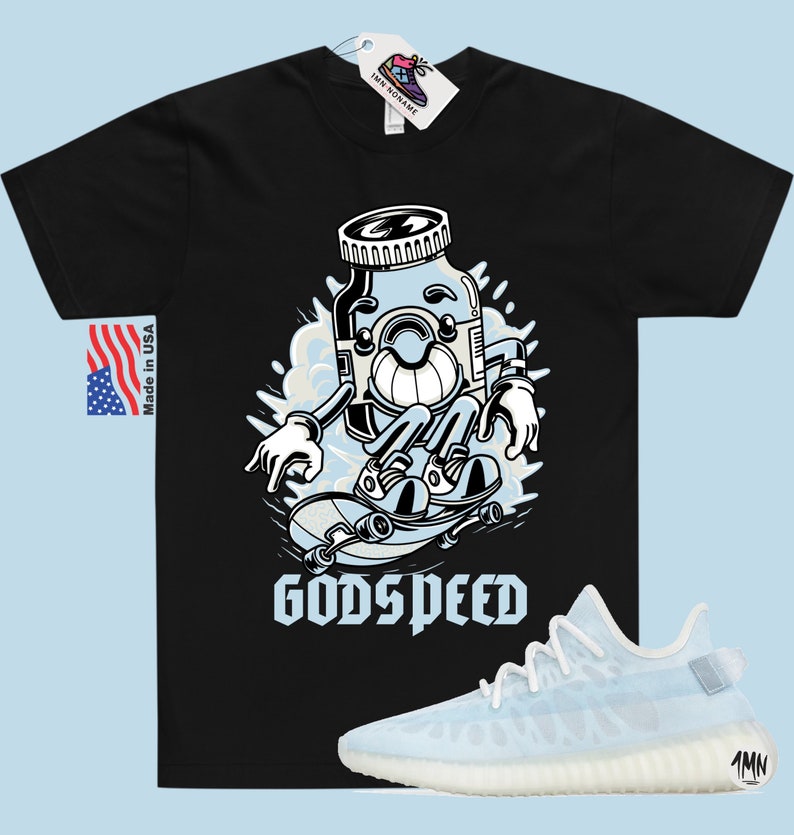 K&ouml;nnte beinhalten: Schwarzes T-Shirt mit einer Cartoon-Illustration einer blauen Pille auf einem Skateboard. Der Text "GODSPEED" ist unter der Illustration gedruckt. Ein Paar wei&szlig;e und hellblaue Sneaker sind unter dem T-Shirt abgebildet.