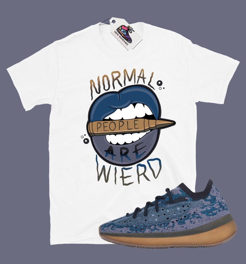 Op de afbeelding: Wit T-shirt met een blauwe en bruine afbeelding met de tekst "Normal People Are Wierd". De afbeelding is een cartoonmond met een kogel erin. Een paar blauwe en bruine sneakers bevinden zich in de rechterbenedenhoek van de afbeelding.