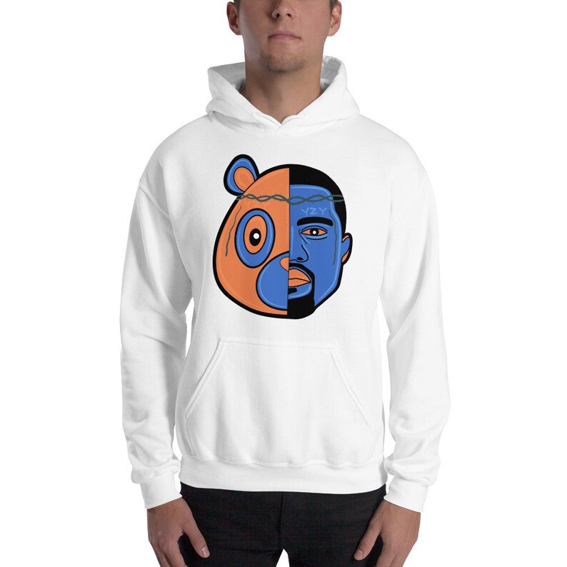 May include: White hooded sweatshirt with a graphic of a cartoon bear and a man's face, split down the middle. The bear is orange and blue, and the man's face is blue. The man has a barbed wire crown on his head with the letters "YZY" written on it.