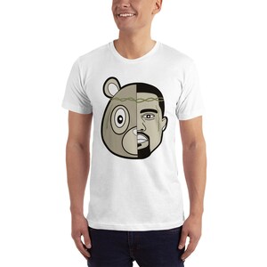 May include: White t-shirt with a graphic of a bear head and a man's face, split down the middle. The bear has a green leafy crown.