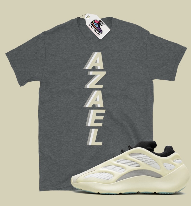 May include: A grey t-shirt with the word "AZAEL" printed vertically in a light beige color. A pair of white and black sneakers with a unique design.