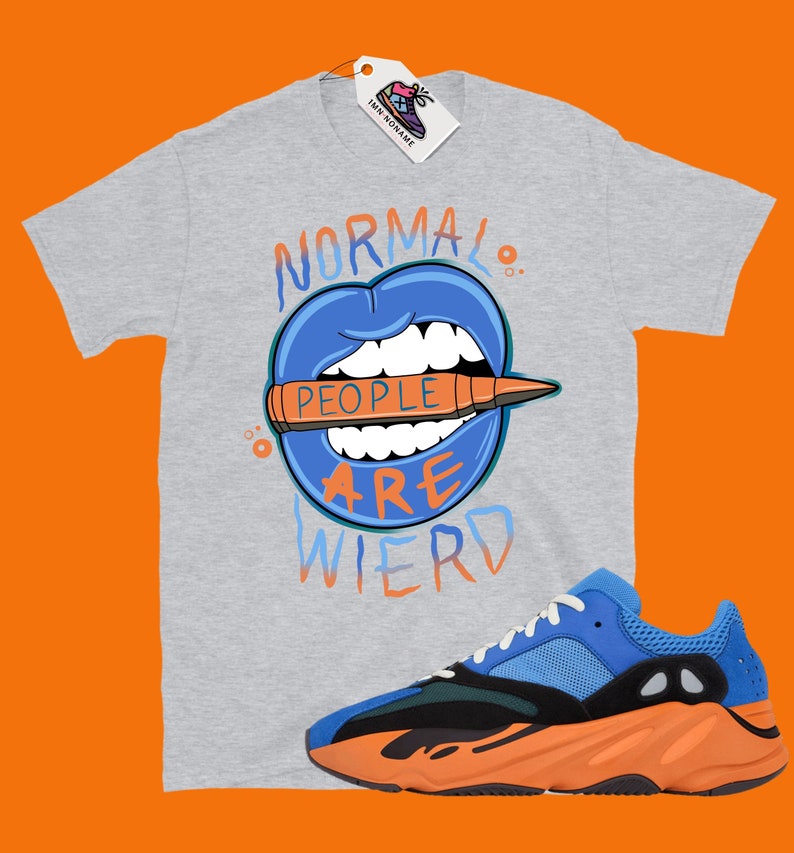 May include: A gray t-shirt with a blue mouth graphic and the text "Normal People Are Wierd". The shirt is paired with blue and orange sneakers.