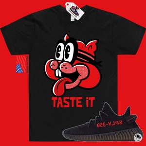 May include: Black t-shirt with a red cartoon character with the text "TASTE IT" and a pair of black and red sneakers with the text "YZY-350" on the side.