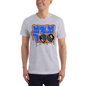 May include: A gray t-shirt with a blue and orange graphic design that says "YZY TOO" with sunglasses on top of the text.