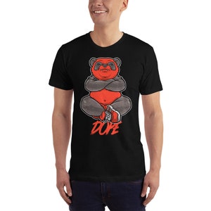 Może przedstawiać: Czarny T-shirt z ilustracją czerwonego i szarego pandy w butach sportowych i napisem "DOPE" czerwonymi literami.