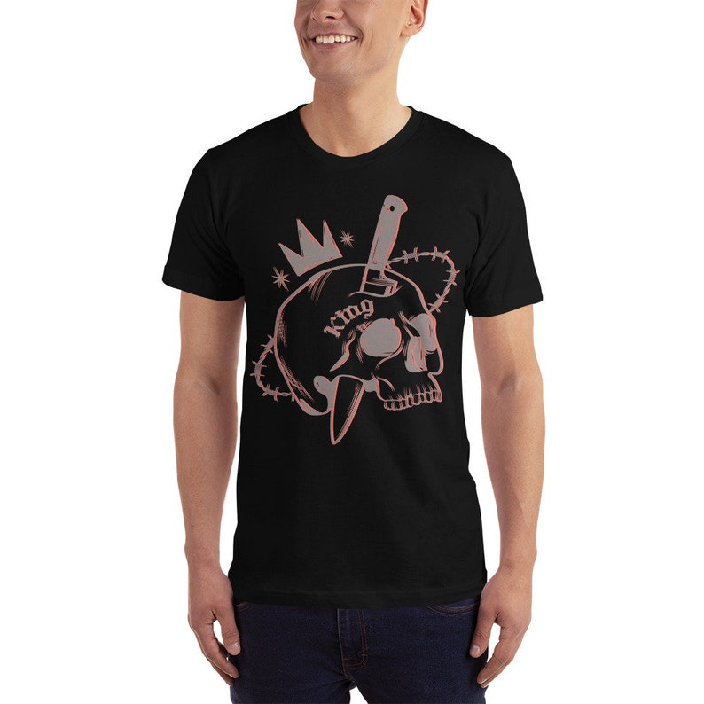 May include: Black t-shirt with a graphic of a skull with a knife through it. The skull has a crown on top and the word "King" tattooed on it.